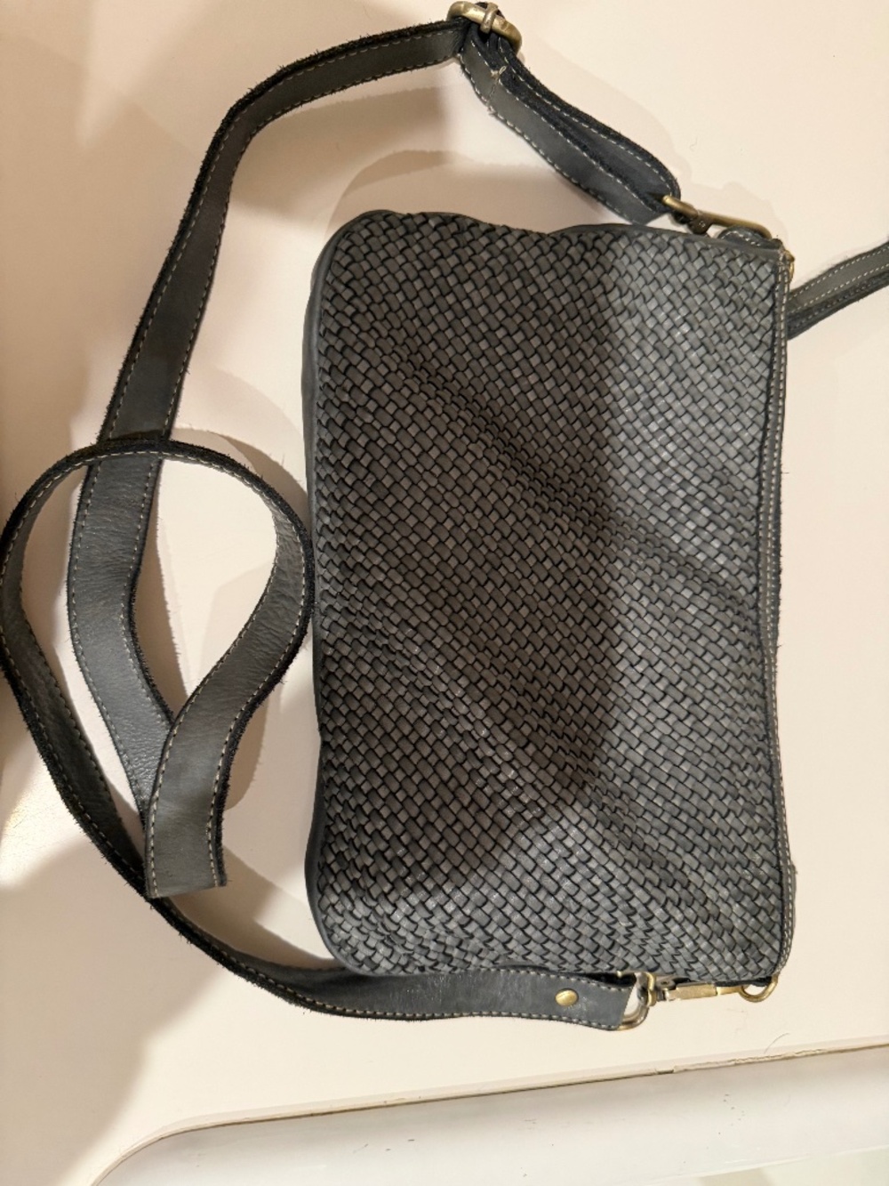 Bolsa Nova Black woven leather crossbody bag with brass hardware